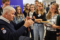 Ein Redner umzingelt von Zuhörern